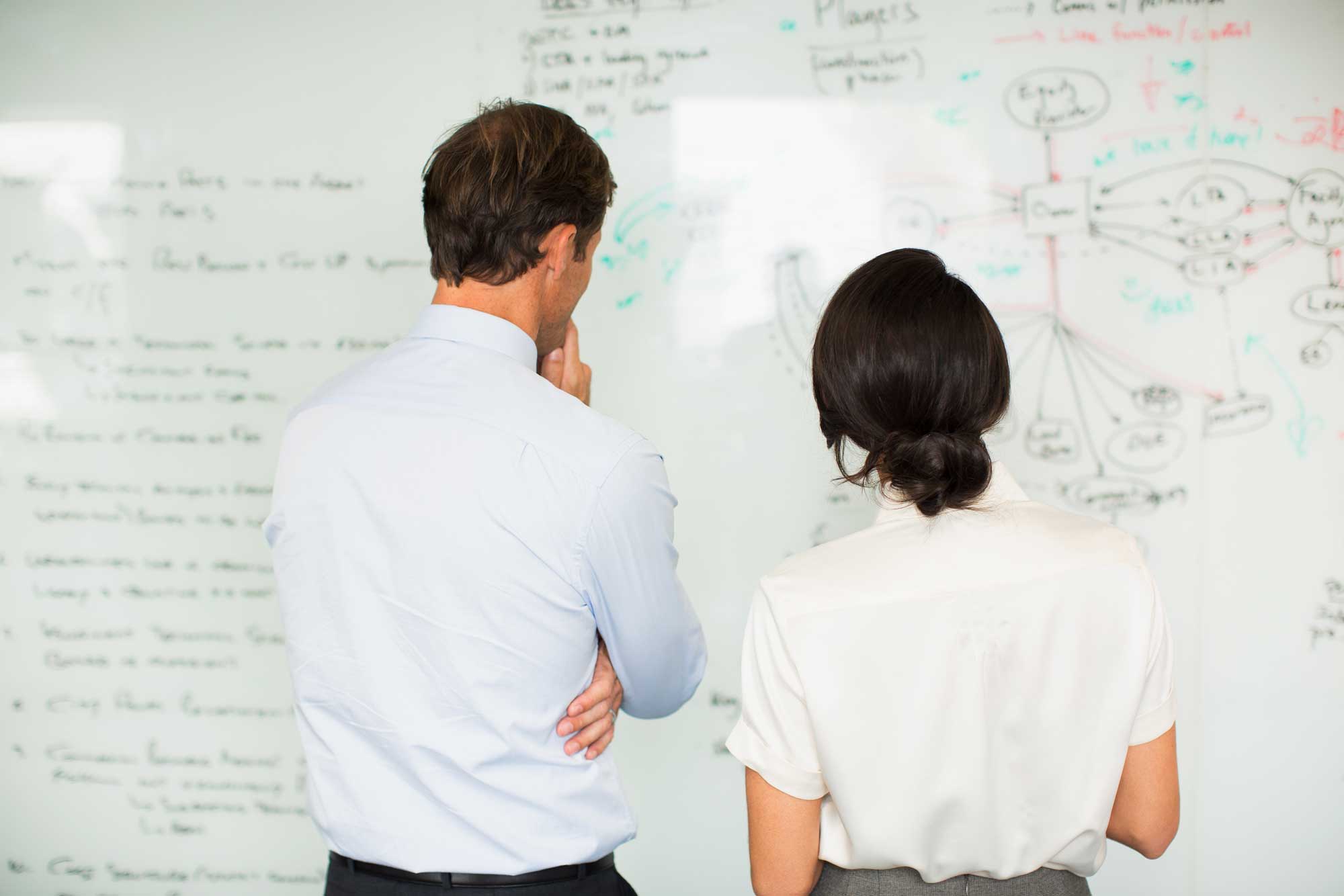 business-people-reading-whiteboard-in-office